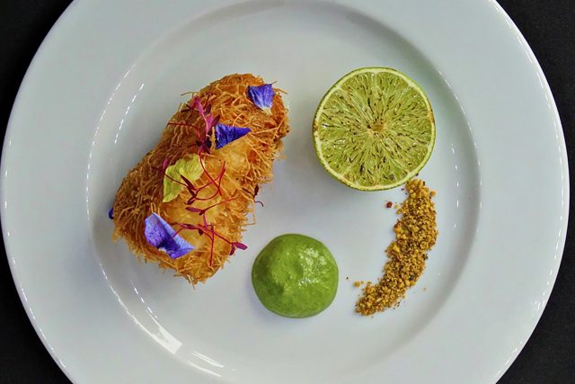 A vibrant serving of crispy kataifi bonda accompanied by a fresh green chutney, showcasing our contemporary Indian culinary presentation in Petts Wood.