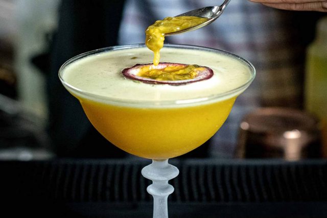A refreshing passion fruit and chutney martini served in an elegant coupe glass, showcasing the contemporary cocktails at our Petts Wood Indian restaurant.