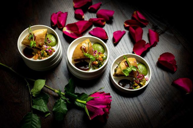 Gourmet Indian appetisers garnished with rose petals and served with vibrant chutneys, showcasing the romantic Valentine's Day menu at our Petts Wood restaurant.