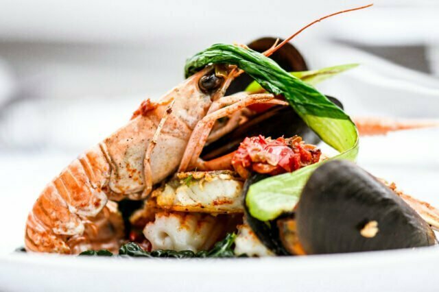 A delicately prepared langoustine and mussel seafood plate, highlighting the contemporary fine Indian dining experience crafted by Chef Atul Kochhar in Petts Wood.