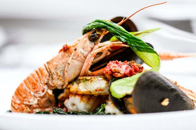 A delicately prepared langoustine and mussel seafood plate, highlighting the contemporary fine Indian dining experience crafted by Chef Atul Kochhar in Petts Wood.