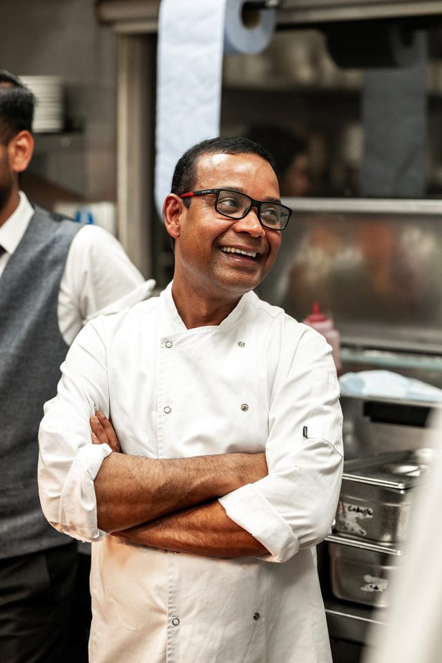 A busy chef working in the Michelin Bib Gourmand kitchen at the regional supper club in Petts Wood preparing fresh Maharashtrian cuisine